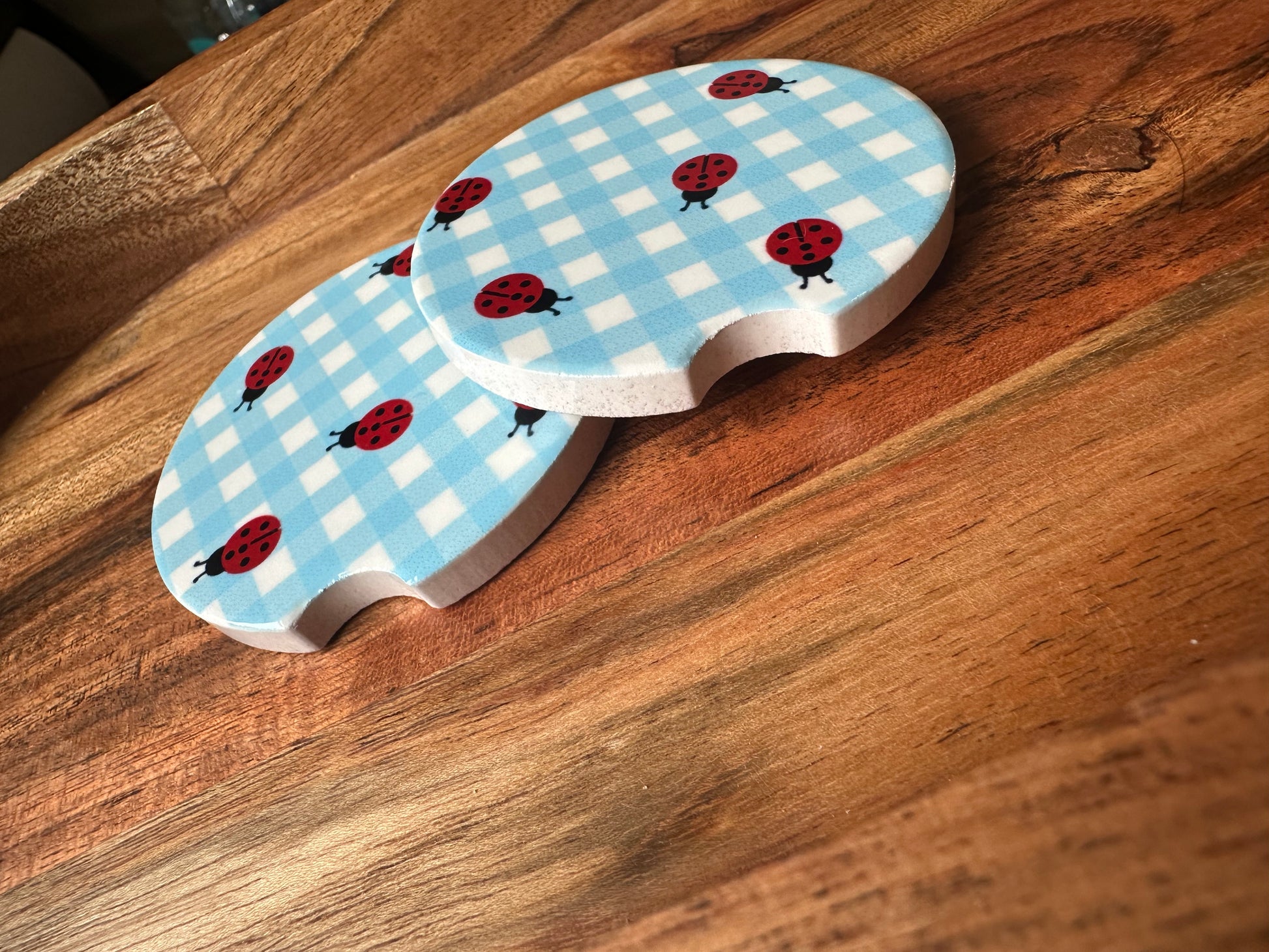 blue white ceramic car coaster with ladybugs stacked on wooden background