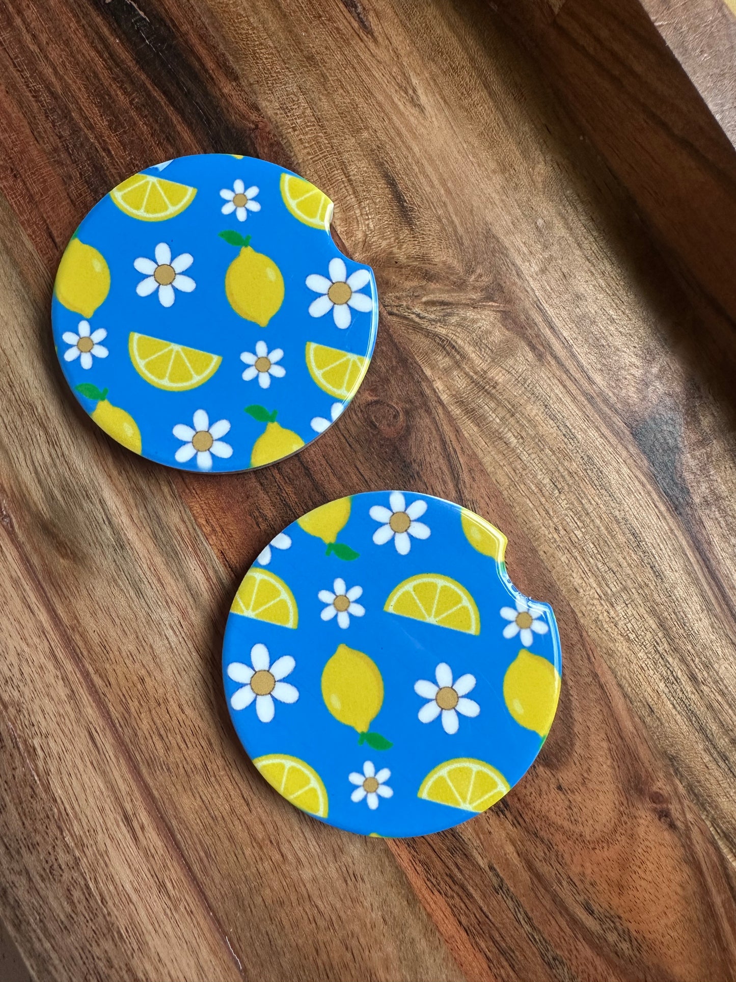 baby blue and lemon print with daisies ceramic car coaster on wooden background