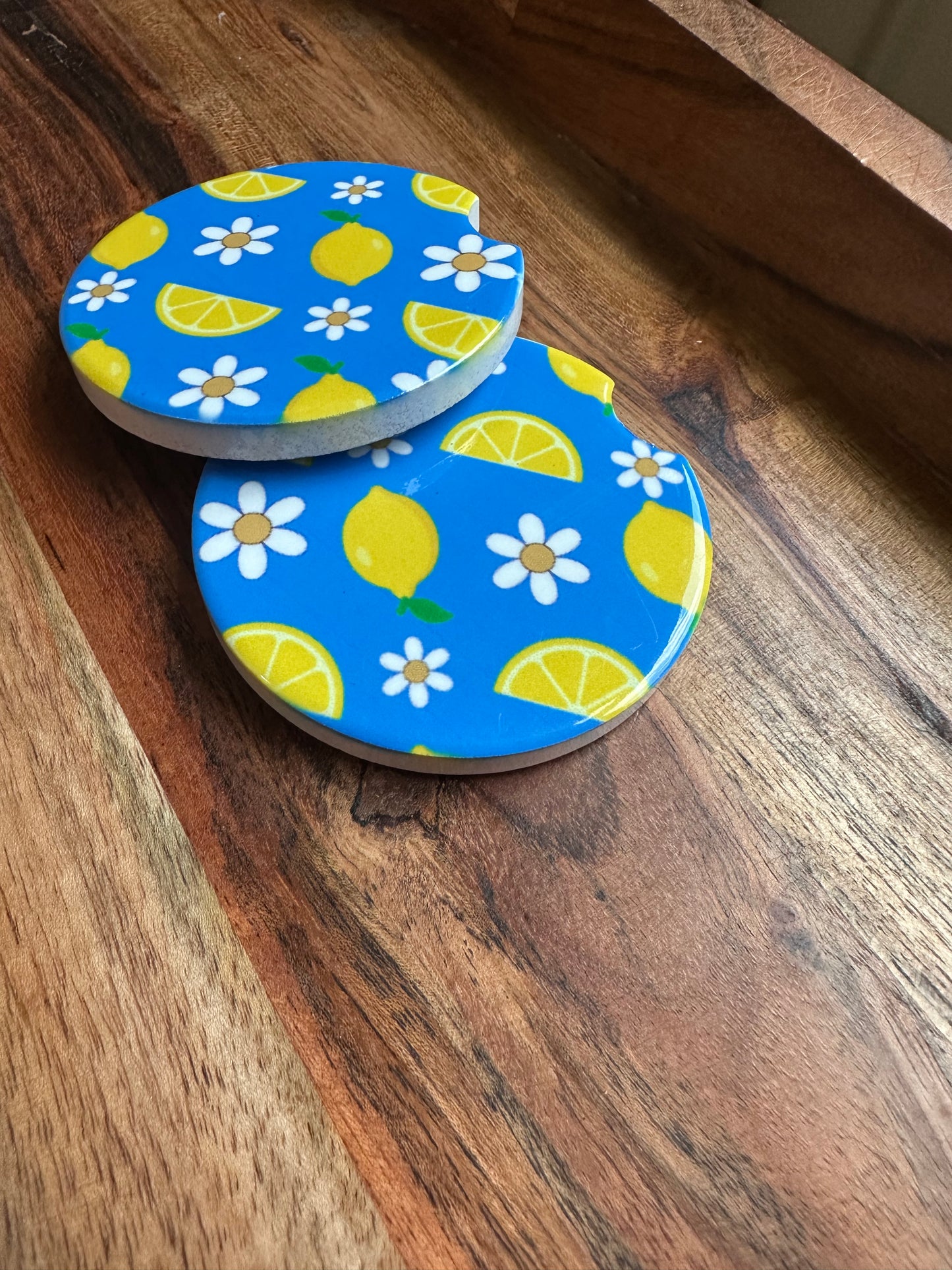 baby blue and lemon print with daisies ceramic car coaster stacked on wooden background