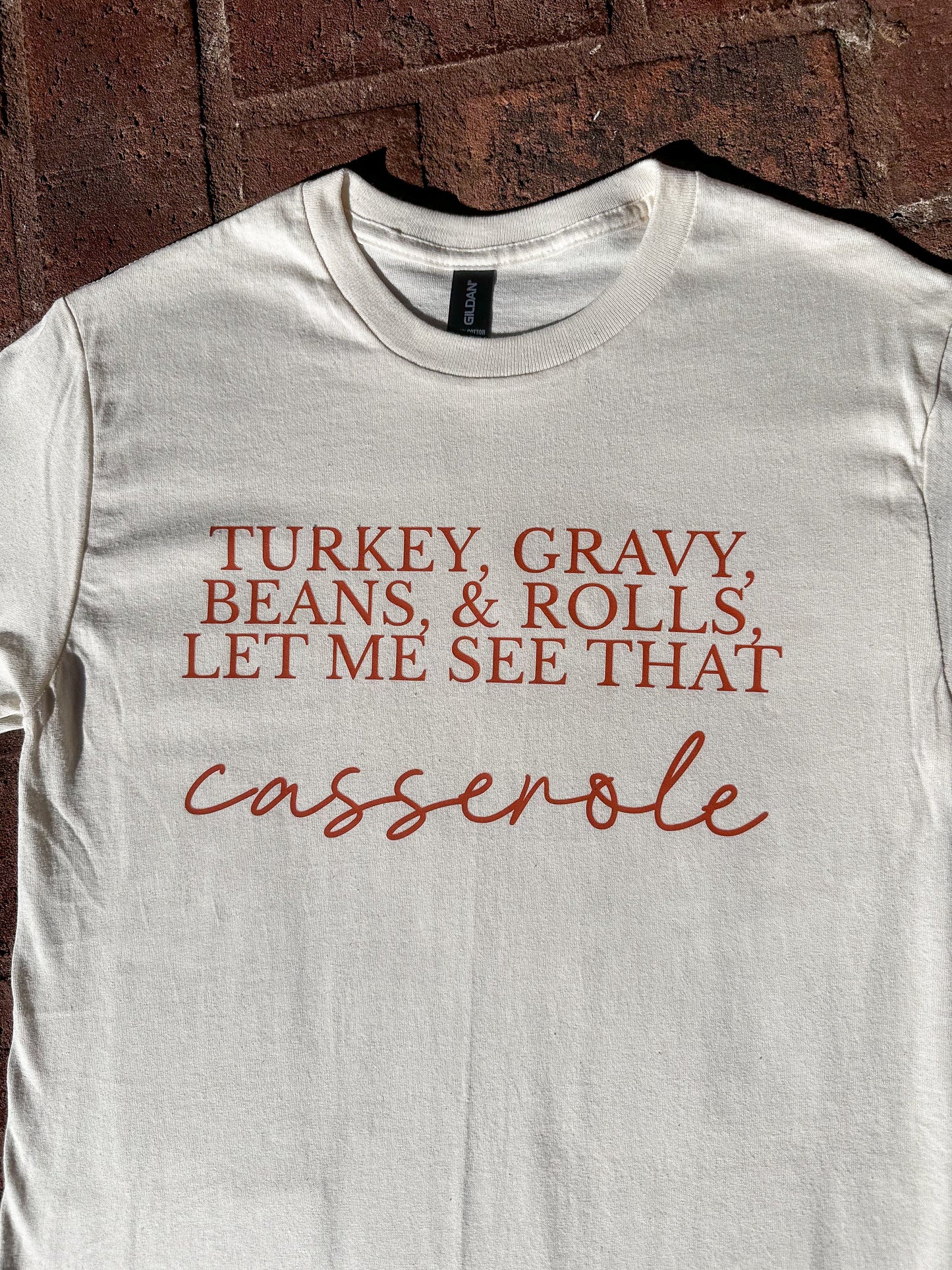 Close-up of DTF printed ‘Turkey, Gravy, Beans & Rolls, Let Me See That Casserole’ graphic on natural Gildan G500 t-shirt.