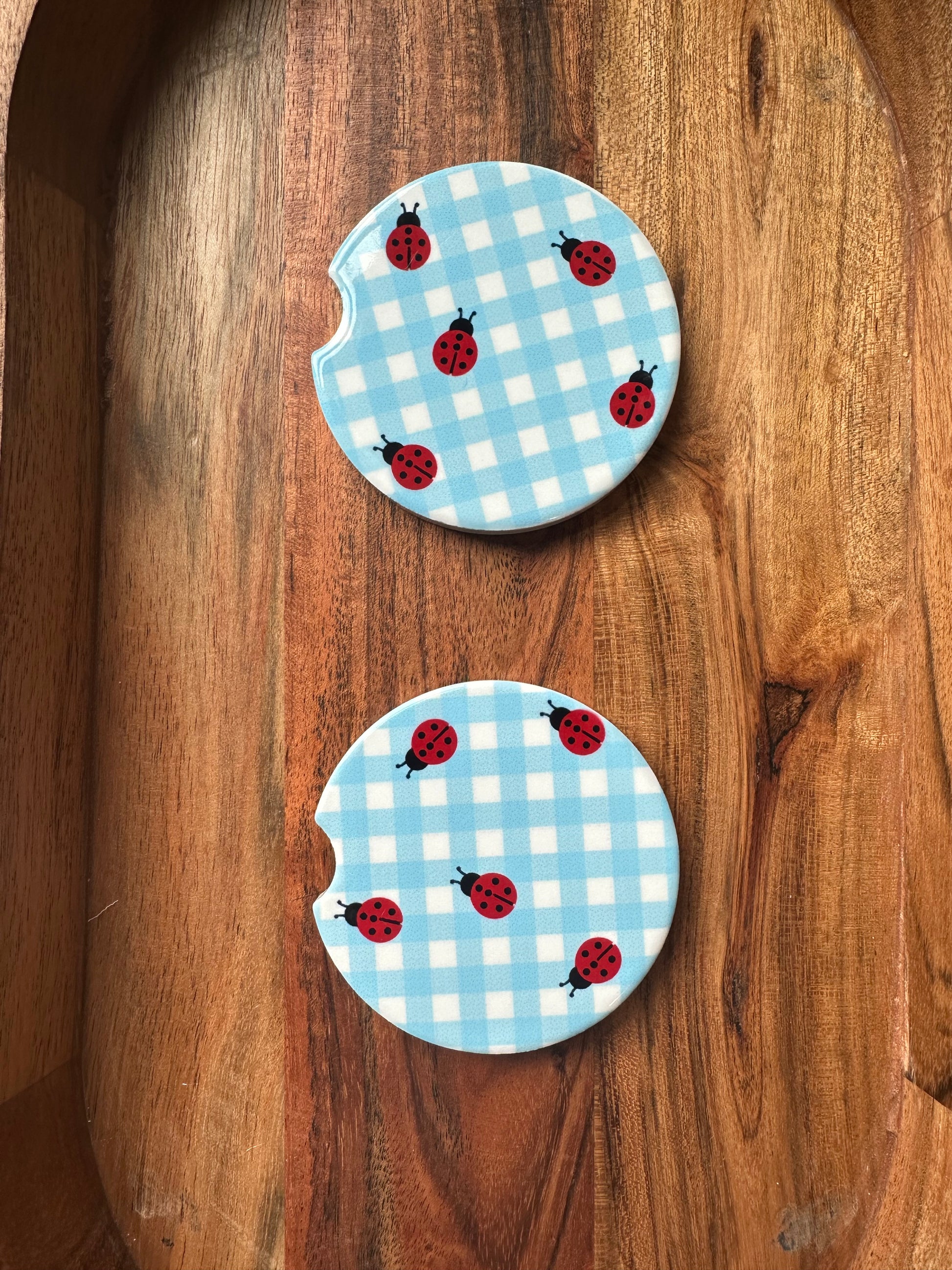 blue white ceramic car coaster with ladybugs on wooden background