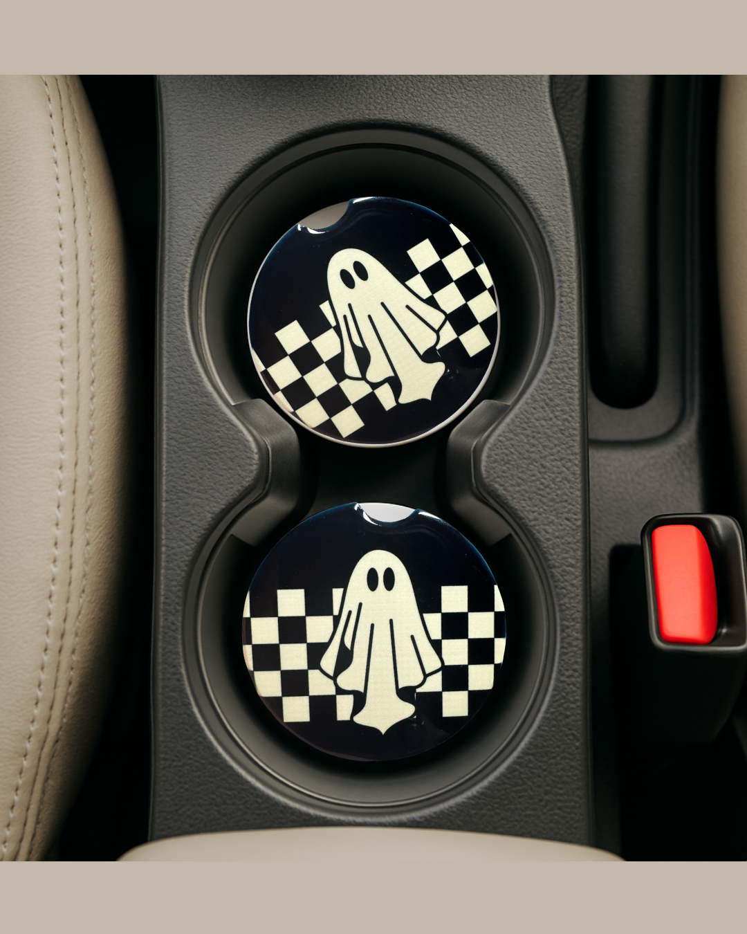 ghosty vibes, a black background with checkered print and a ghost on the front of a ceramic car coaster in a car's cup holders