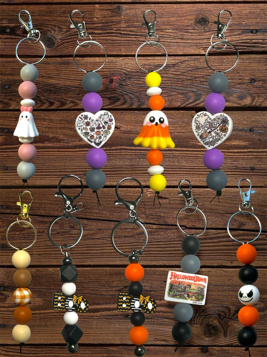 silicone beaded fall and Halloween themed standalone keychains with silver hardware on a wooden table