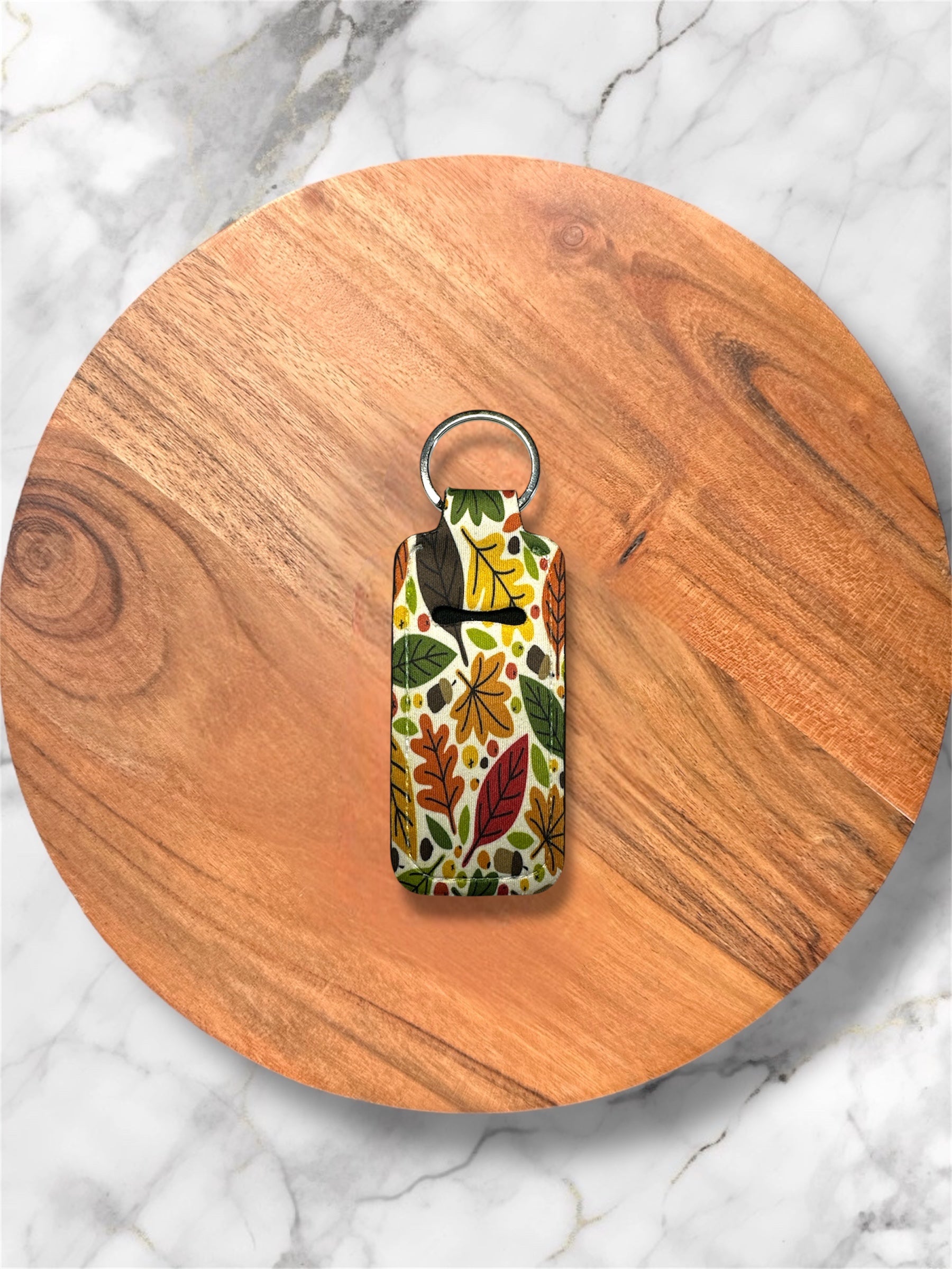 Cream fall/ Autumn patterned lip balm holder keychain on a wooden circle with a marble background