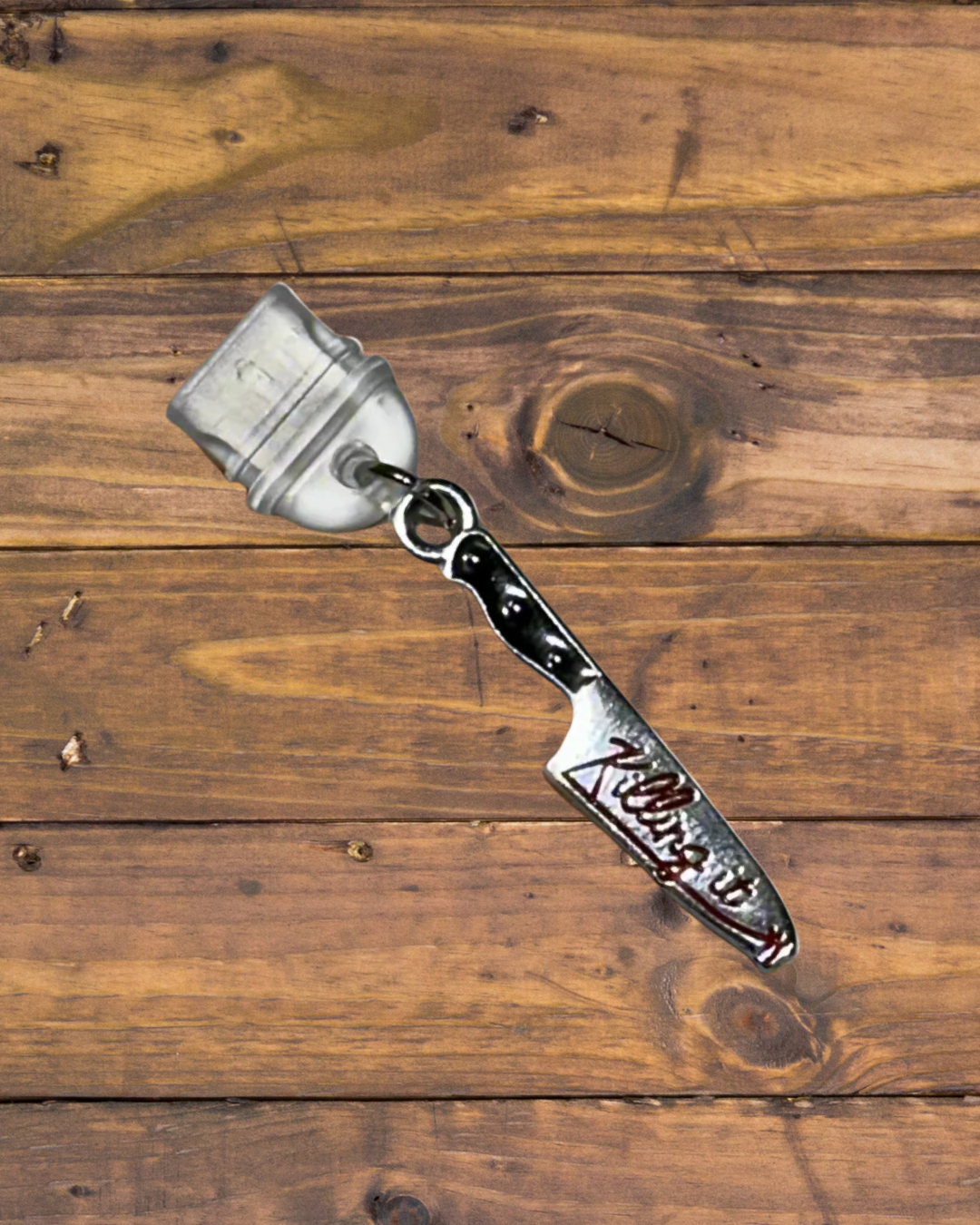 usb- c dust plug with a knife charm with 'Killing it' engraving on it