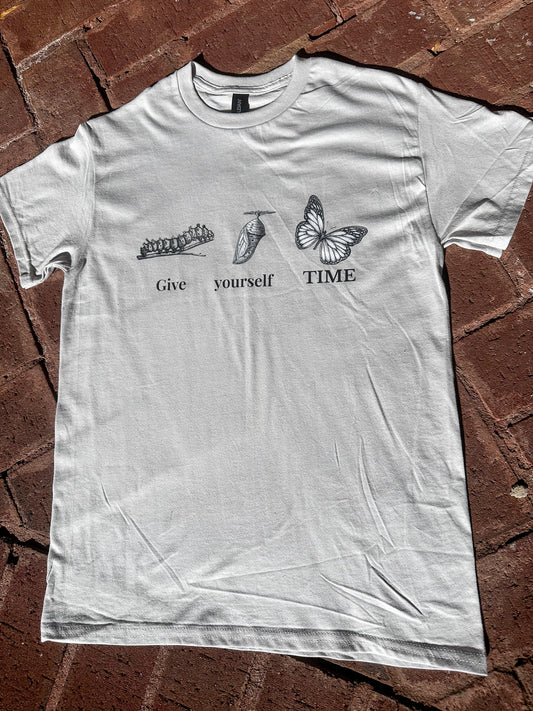 Gildan G500 ice grey unisex graphic tee with positive message displayed on brick surface